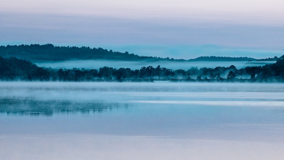 Stille meer met mistblauwe lucht en bladeren. Stille meer met mistblauwe lucht en bladeren.